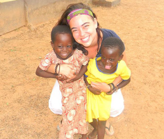 Voluntario feliz con niños en Ghana