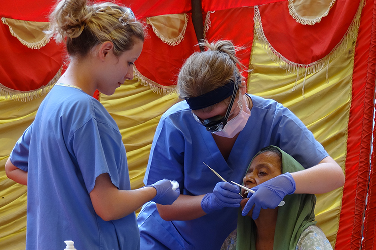 Estudantes de odontologia do Reino Unido trabalhando em um acampamento dental na Índia>