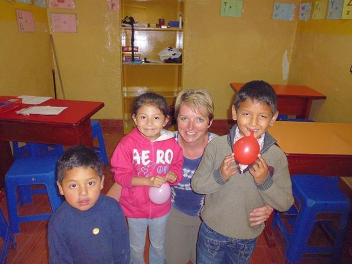 female volunteer with smiling students
