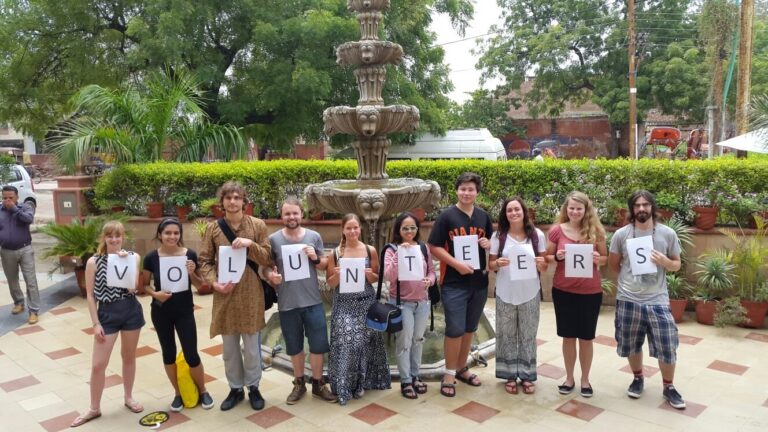 University volunteer group in India holding up letters that spell VOLUNTEERS