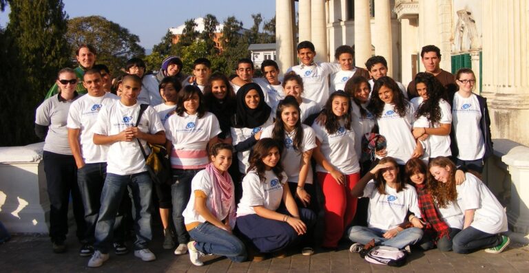 Large group of school and university students in matching T-shirts on a group volunteering trip