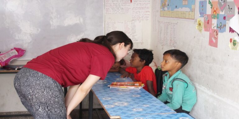 Volunteer working one to one with two schoolboys at a community education project in Jaipur
