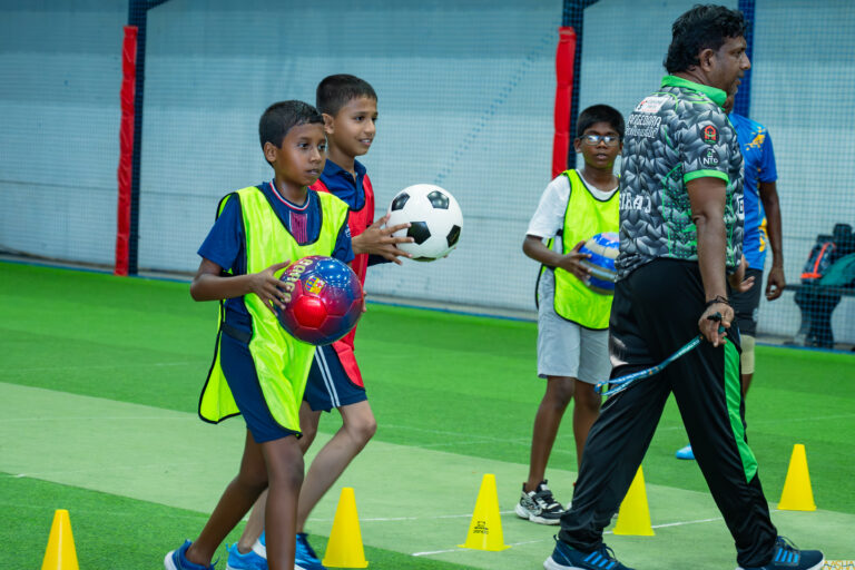 A local coach and children with footballs during a drill at the indoor pitch used by the Sri Lanka sports coaching programme in Galle