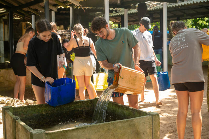 Volunteers filling water containers on a community project