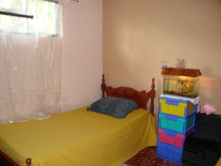 A volunteer's room in a host family home, with a single bed and storage